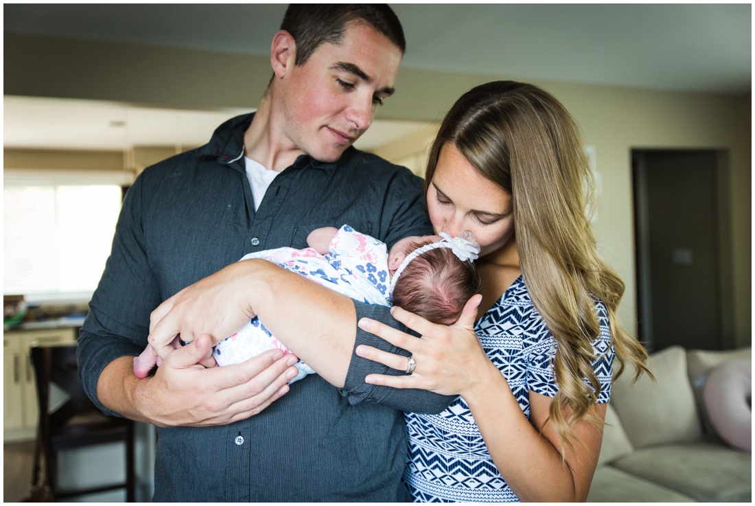 Chatham ON Lifestyle Newborn Photographer, Brittany VanRuymbeke Photos + Films, new parents holding and kissing newborn daughter