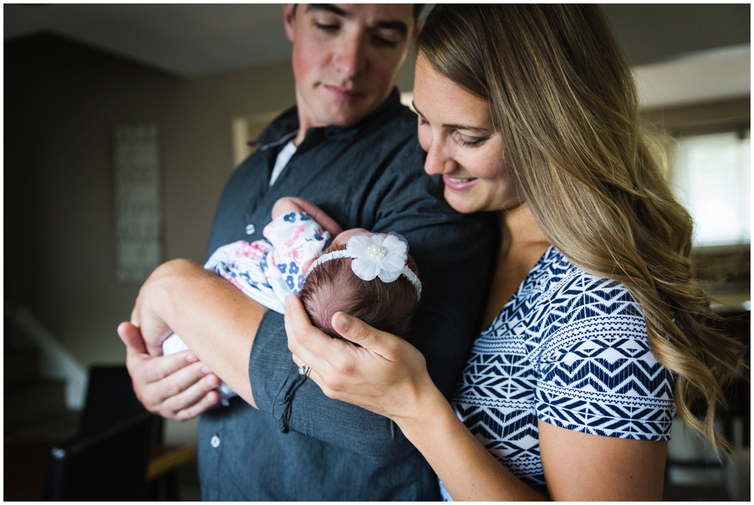 Chatham ON Lifestyle Newborn Photographer, Brittany VanRuymbeke Photos + Films, new parents holding newborn daughter smiling