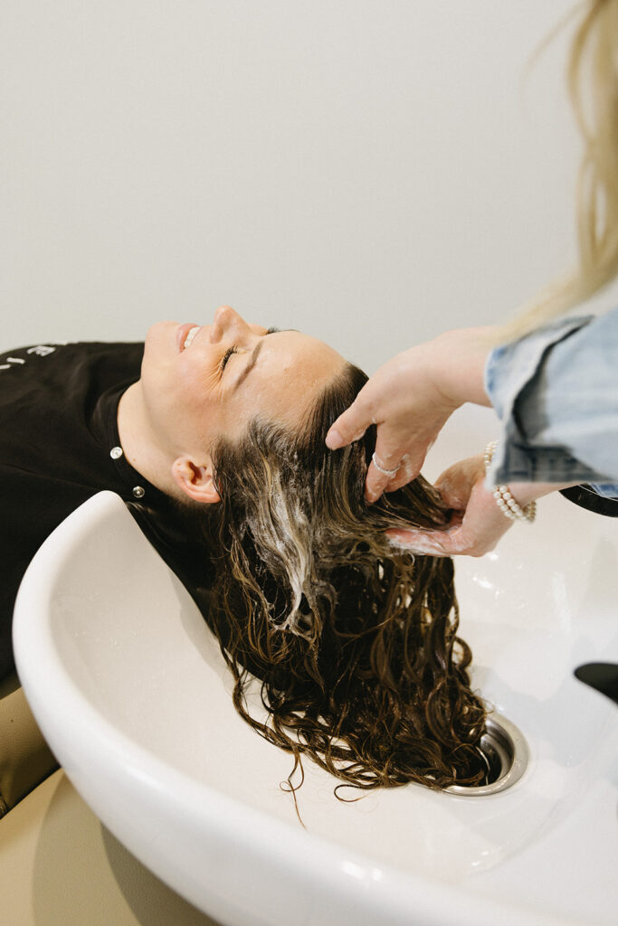 Close up of hands styling washing hair during Sarnia brand photography session