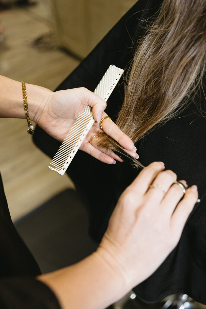 Close up of hands cutting hair at stylish salon brand session