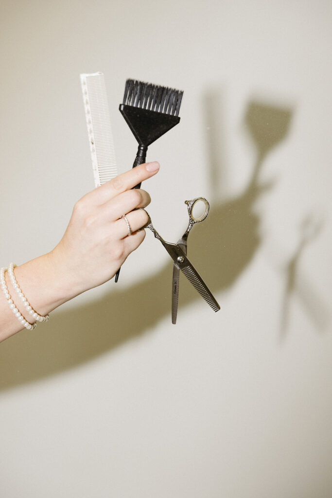 Close-up of hands holding styling salon supplies, faceless brand content