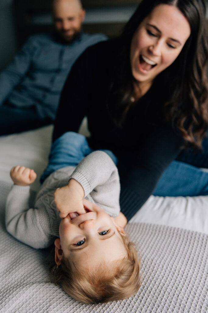 Mom and dad playing with toddler during in home family session in chatham ontario