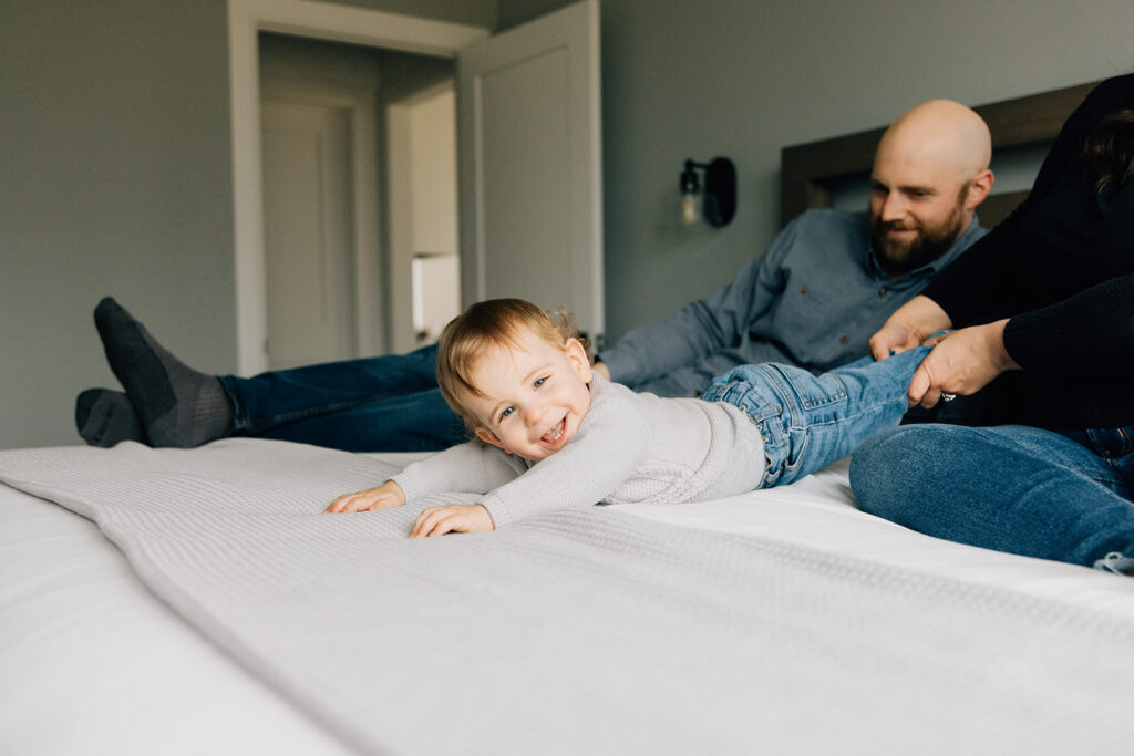 Mom and dad playing with toddler during in home family session in chatham ontario