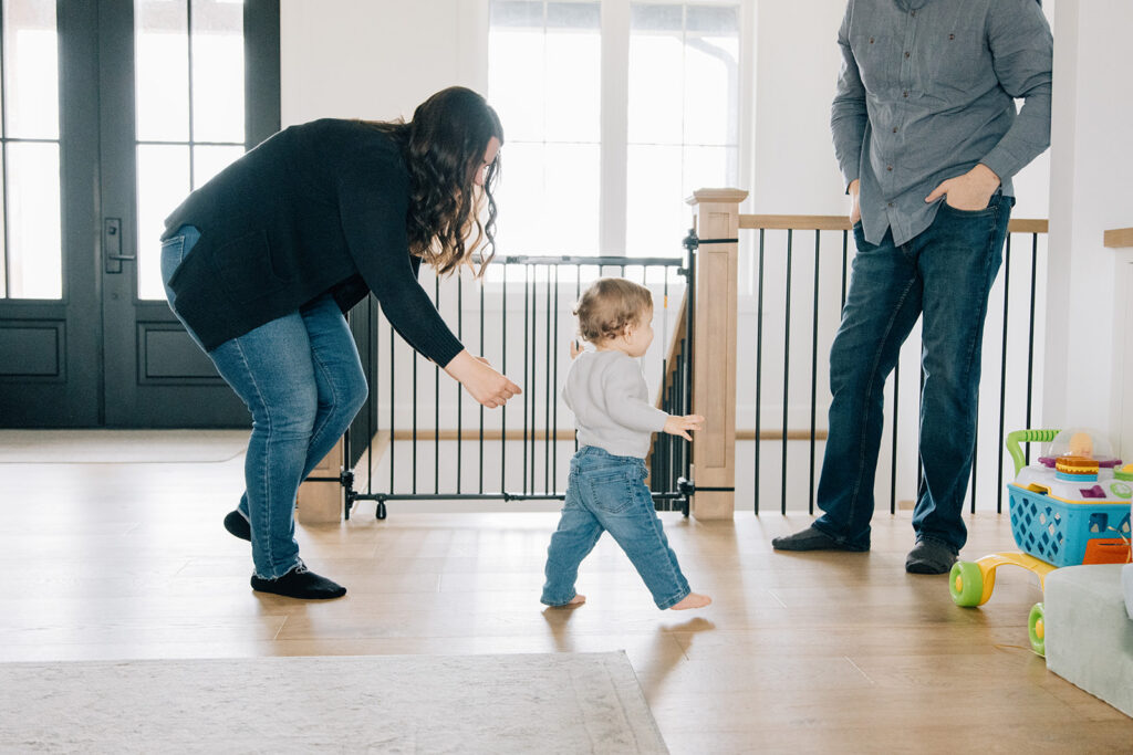 Mom and dad chasing toddler during in-home family photo session in Chatham-Kent, Ontario