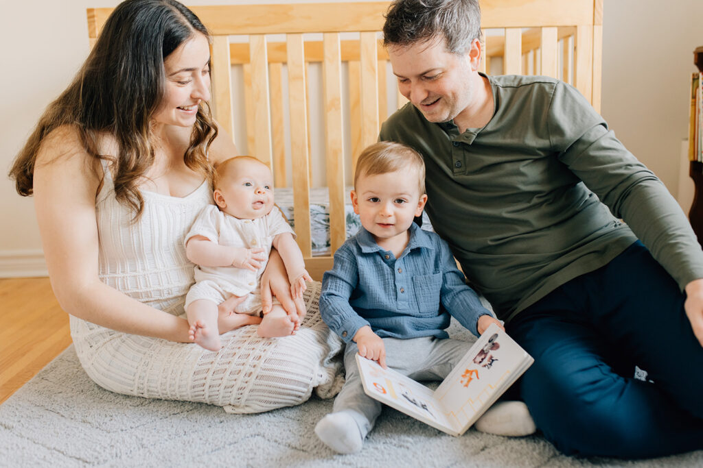 Family reading together in nursery during in home family session in sarnia