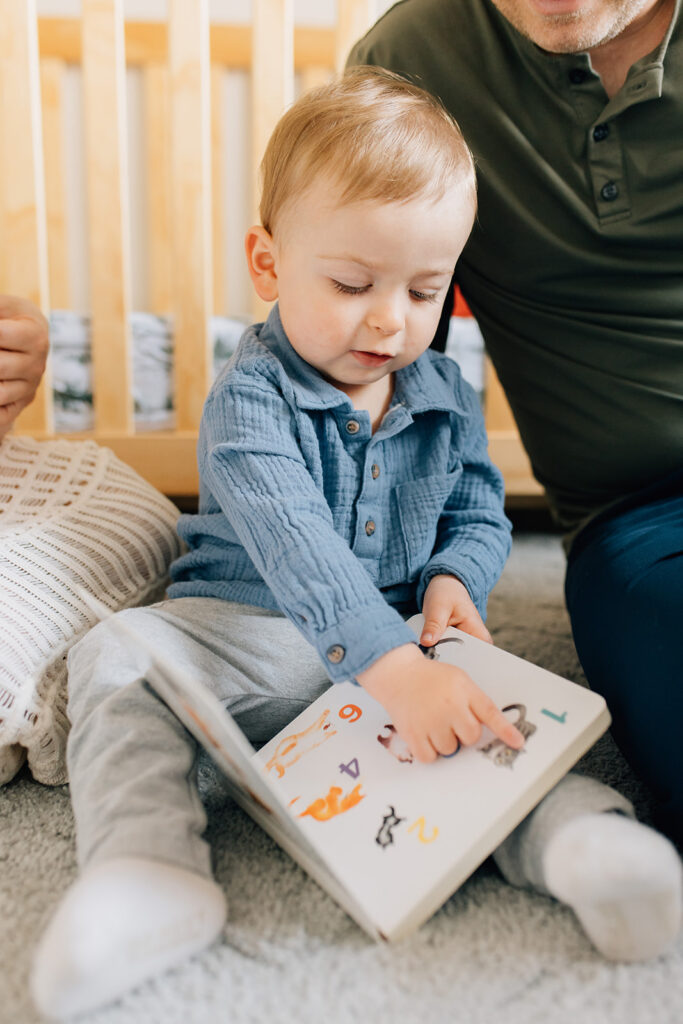 Family reading together in nursery during in home family session in sarnia