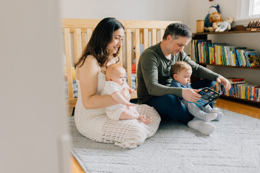 Family reading together in nursery during in home family session in sarnia